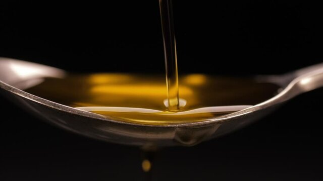 pouring olive oil into spoon slow motion