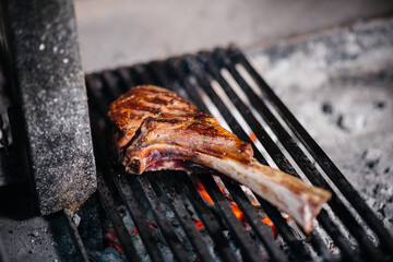 Juicy steak is grilled in a restaurant. Roasting meat in the fire on the grill.