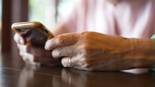 senior woman reading news from smartphone