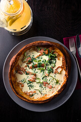 savory dutch baby pancake with egg, bacon, traditional Dutch breakfast top view, flat lay