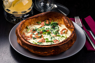 savory dutch baby pancake with egg, bacon, traditional Dutch breakfast