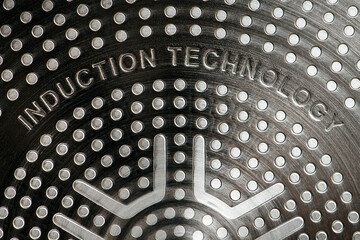Bottom of induction cookware. Texture of a non-stick induction pan close-up