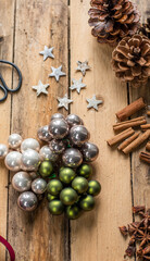 Weihnachtsdekoration mit Kugeln, Zapfen, Zimt und Sternen auf Hintergrund aus Holz