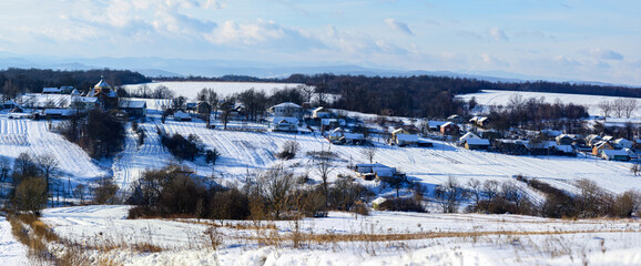 Fototapeta na wymiar Ukrainian snow-covered villages, panorama of winter and evening villages.