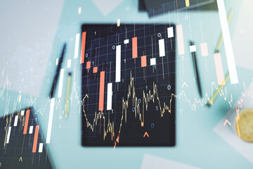 Multi exposure of abstract financial graph with world map and modern digital tablet on desktop on background, top view, financial and trading concept