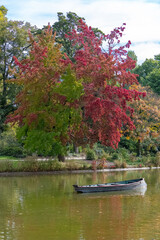 A row boat on the Vincennes lake in autumn, with reflection of the trees
