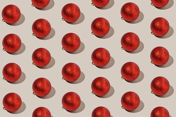 Simple pattern made of red baubles on pastel background. Creative winter composition. Christmas party and festive concept. Minimal style.