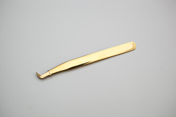 tools for eyelash extensions and eyebrow design. cosmetic tweezers in gold color on a white background