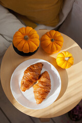 Seasonal coffee and freshly baked croissants with pumpkins at a cafe