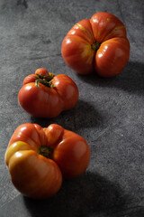 several fused red tomatoes on a black background