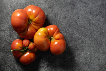 several fused red tomatoes on a black background