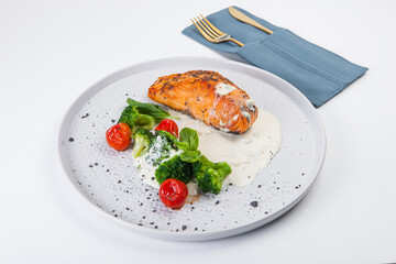 salmon steak, sauce, tomatoes, white plate