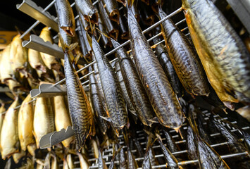 Industrial smoking of fish. Mackerel hangs on special metal rods in a smoking oven. © nordroden