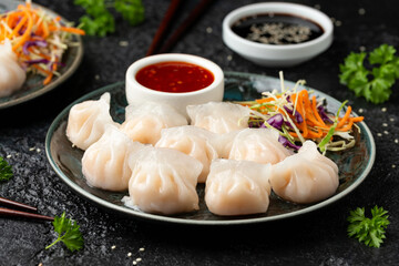 Traditional Asian Prawn or shrimp dumplings hakau, ha kauw or har gow. Served with cabbage, carrot salad and soy and sweet chilli sauce