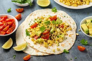 Scrambled Tofu Tacos with avocado, tomatoes and green herbs. Healthy Vegan Breakfast.