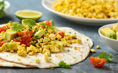 Scrambled Tofu Tacos with avocado, tomatoes and green herbs. Healthy Vegan Breakfast.
