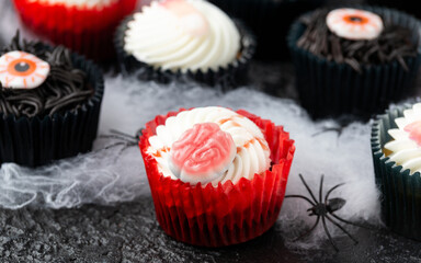 Halloween cupcakes decorated with finger, brain and eye candy.