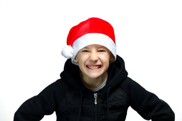 a boy in a red Santa hat shows threatening gestures and grinned