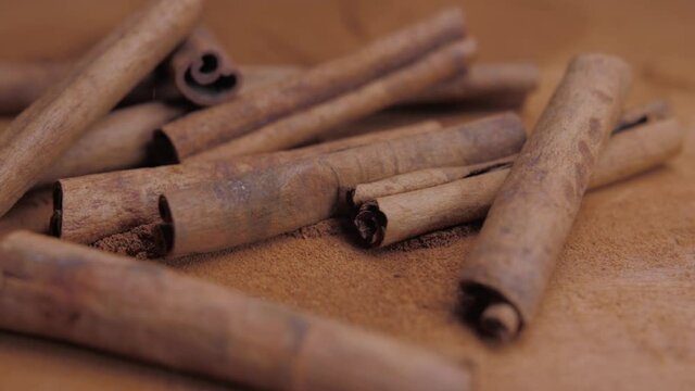 cinnamon sticks falling into powdered cinnamon slow motion 