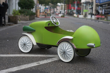 Closeup of wooden vintage car for children parked in the street