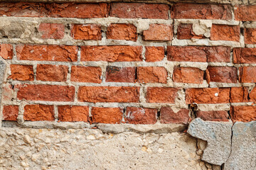 Old, dilapidated cracked brick wall.