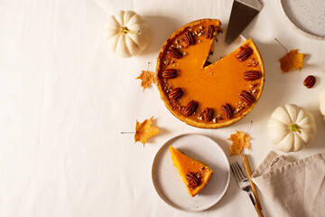 Traditional pumpkin pie on table, flat lay with pumpkins