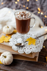 Obraz na płótnie Canvas Autumn composition with hot chocolate with marshmallow. Aromatherapy on a grey fall morning, atmosphere of cosiness and relax. Wooden background, window sill, close up