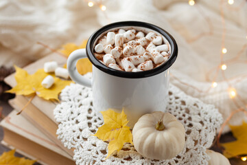 Autumn composition with hot chocolate with marshmallow. Aromatherapy on a grey fall morning, atmosphere of cosiness and relax. Wooden background, window sill, close up