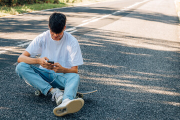 Fototapeta premium boy with skateboard and headphones on the road