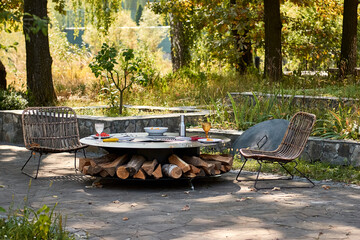 Fototapeta na wymiar Kettle Grill Pit with Cast Iron Grid with flames . Round table-cooking surface. Hot BBQ on Backyard