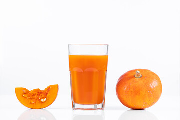 Pumpkin juice in transparent glass isolated on white background. Vegetable vegetarian drink. Healthy food and diet.