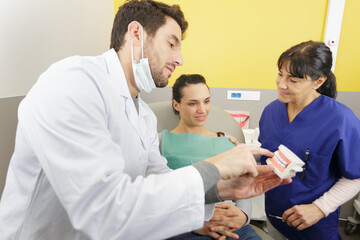 dentist using prosthetic model to explain to patient