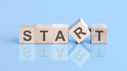 Wooden blocks with words 'START' on beautiful blue background, copy space. Business concept.