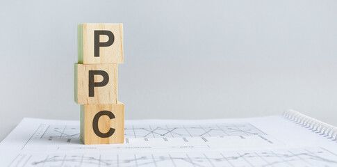 PPC - Pay Per Click acronym, wooden blocks, business concept, gray background