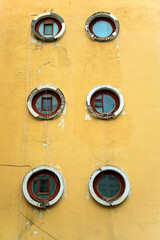 yellow wall with round windows portholes