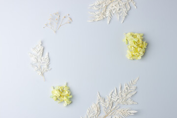 Cosmetic background with flowers on grey. Flat lay, copy space