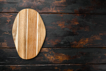 Pine wooden cutting board, on old dark  wooden table background, top view flat lay , with copy space for text or your product