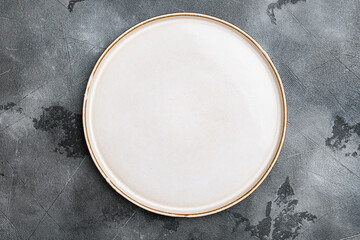 Porcelain empty white plate with copy space for text or food with copy space for text or food, top view flat lay , on gray stone table background