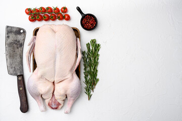 Fresh raw whole duck ready for cooking with herbs, on white stone table background, top view flat...