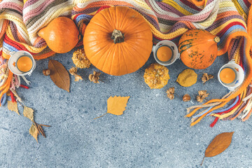 Setting modern elegant gray orange and white themed table with pumpkins centerpiece flat lay