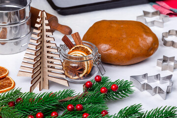 Gingerbread cookies dough, metal cutter, Christmas spices and decoration, horizontal
