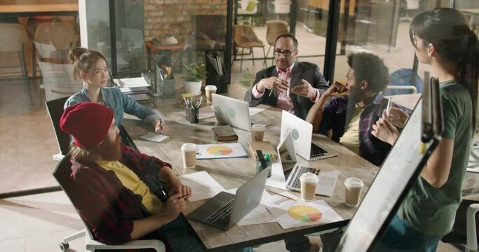 Group of diverse creative young people brainstorming and discussing strategies and ideas for project. Prosperous millennial colleagues analyzing in office 4k footage