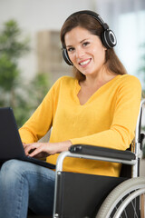 happy disabled woman in wheelchair with laptop