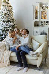 Portrait of beautiful happy family with two children in white sweaters