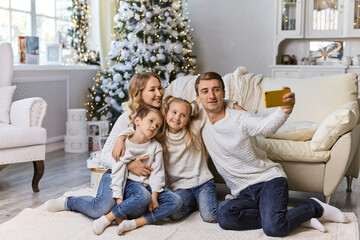 happy family sitting in living room and taking selfie picture with smartphone at home