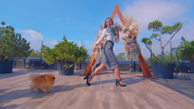 Adorable young girl walking with her cute dog shpitz in warm sunny day, slow-motion.