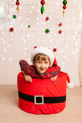 Funny Happy beautiful little boy sitting in a big red box gift