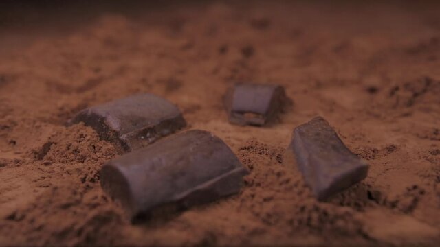 Raw Chocolate Falling Into Cacoa Powder Slow Motion