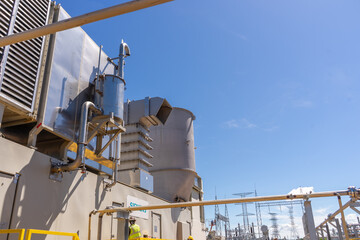 Construction of the firts natural gas energy plant of central america, trucks, construction machinery, workers, turbines and storage tanks.
