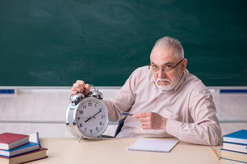 Old male teacher in time management concept